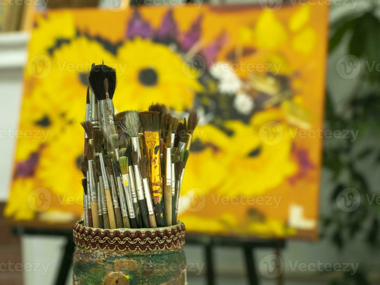 Art brushes in a cup holder on a colored yellow background. photo