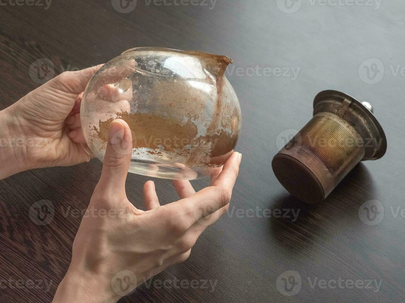 Dirty glass teapot. Tea scale on the teapot. Cleaning the teapot at home. photo