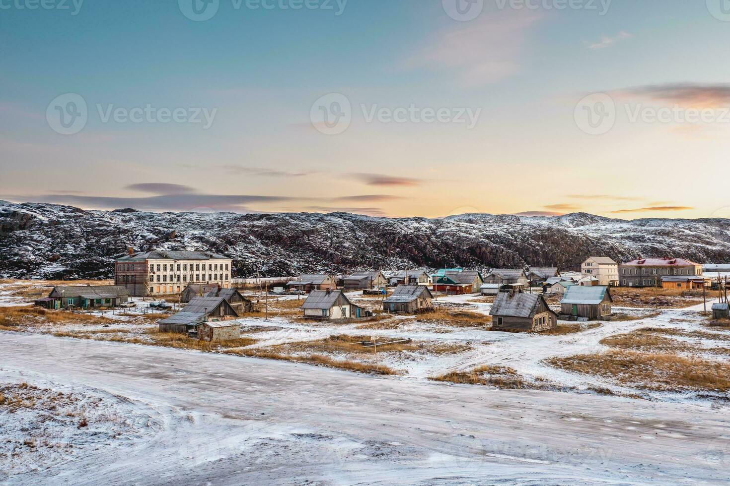 Abandoned houses against the Arctic sky. Old authentic village of Teriberka. Kola Peninsula. photo