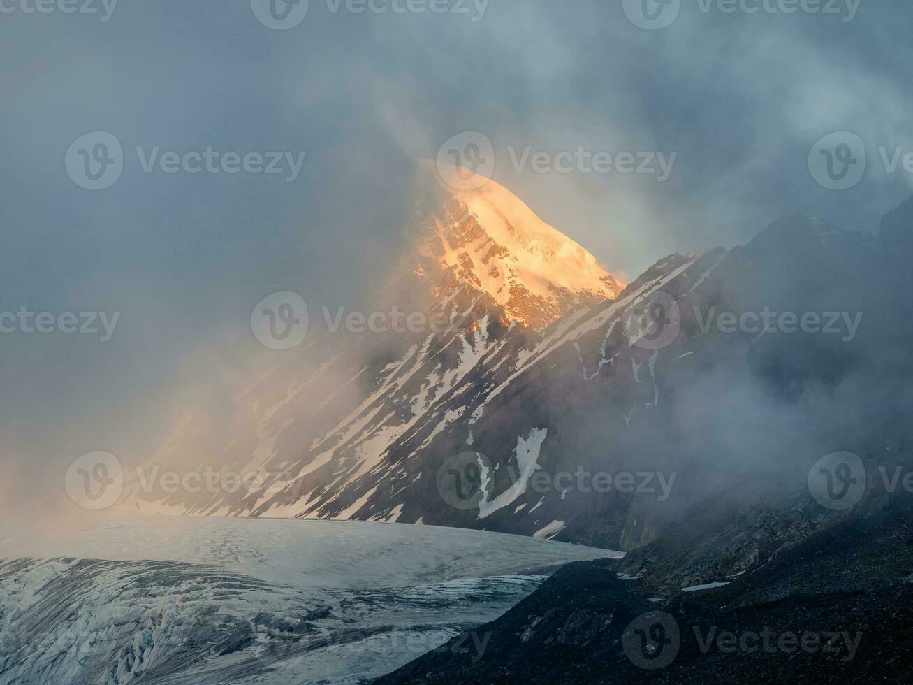 Soft focus. Minimalist mountain landscape with fiery snow peak. Wonderful minimalist landscape with big snowy mountain peaks above low clouds. photo