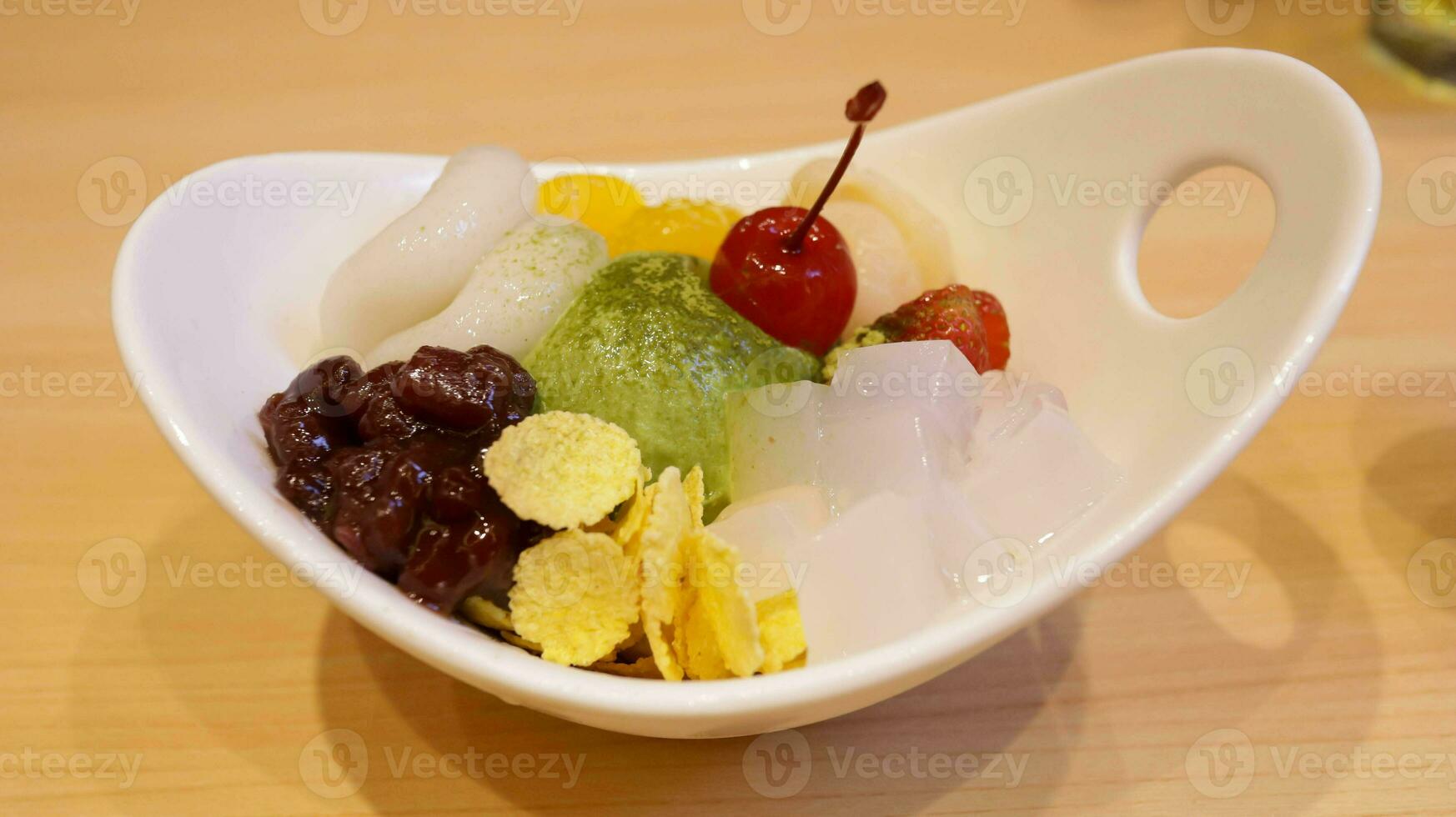 Shiratama Anmitsu is a classic Japanese sweet dumplings served with matcha ice cream, assorted fruits, ogura paste and topped with special brown sugar sauce. photo
