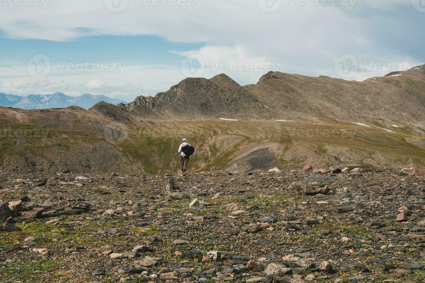 Easy climbing on a rocky mountain slope. Solo trekking in the mountains. Travel photographer lifestyle, hiking hard track, adventure concept in summer vacation. photo