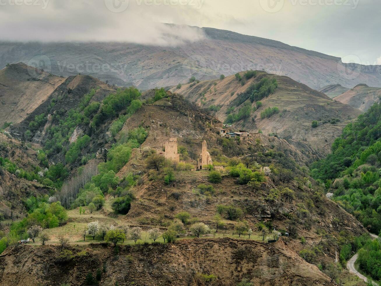 Stone ancient monastery on the green mountain. Memorial complex Vatan, Sogratl village in Dagestan. Russia. photo