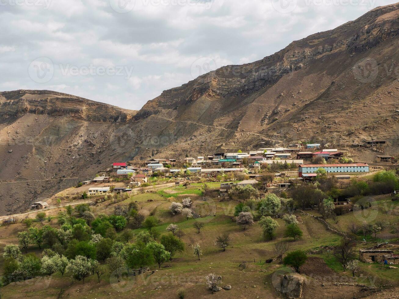 Mountain village in spring greenery. Picturesque ethnic houses on a mountain slope. Dagestan. photo