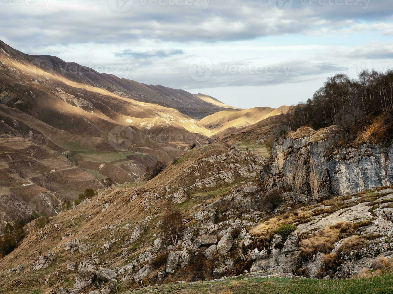 Dramatic alpine scenery with high mountain valley in sunlight and in shadow under cloudy sky. Scenic mountain landscape with changeable weather in highlands. Sunny and overcast. Sunlight and shadow photo