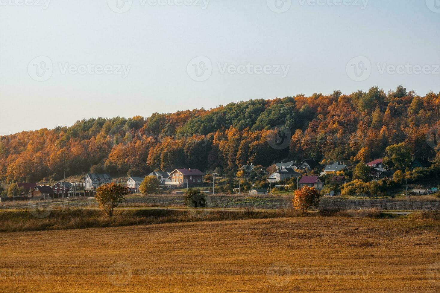 soleado noche paisaje con tierras de cultivo Listo para plantando, con un pueblo en un colina en el otoño antecedentes foto
