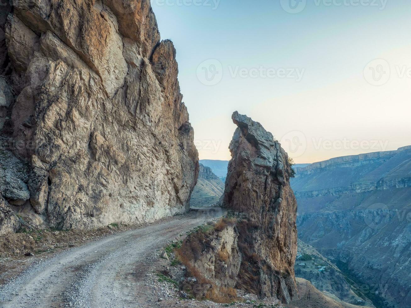 Dangerous narrow cliffside mountain road through sharp rocks.. Dangerous off road driving along mountain edge and steep cliff. Dagestan. photo