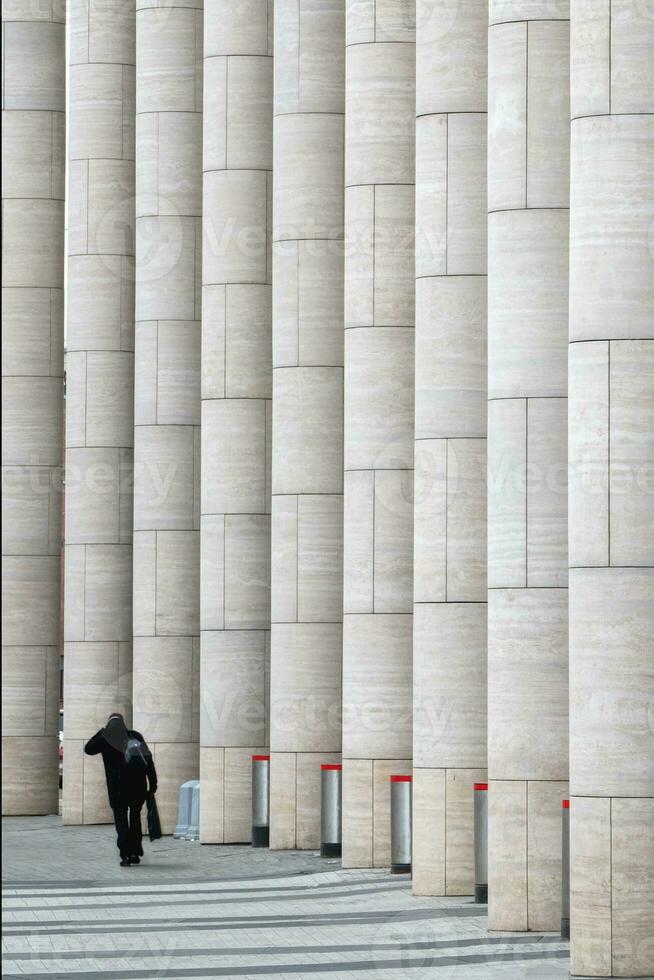 Silhouette of a man at the marble vertical columns of a modern business center. photo