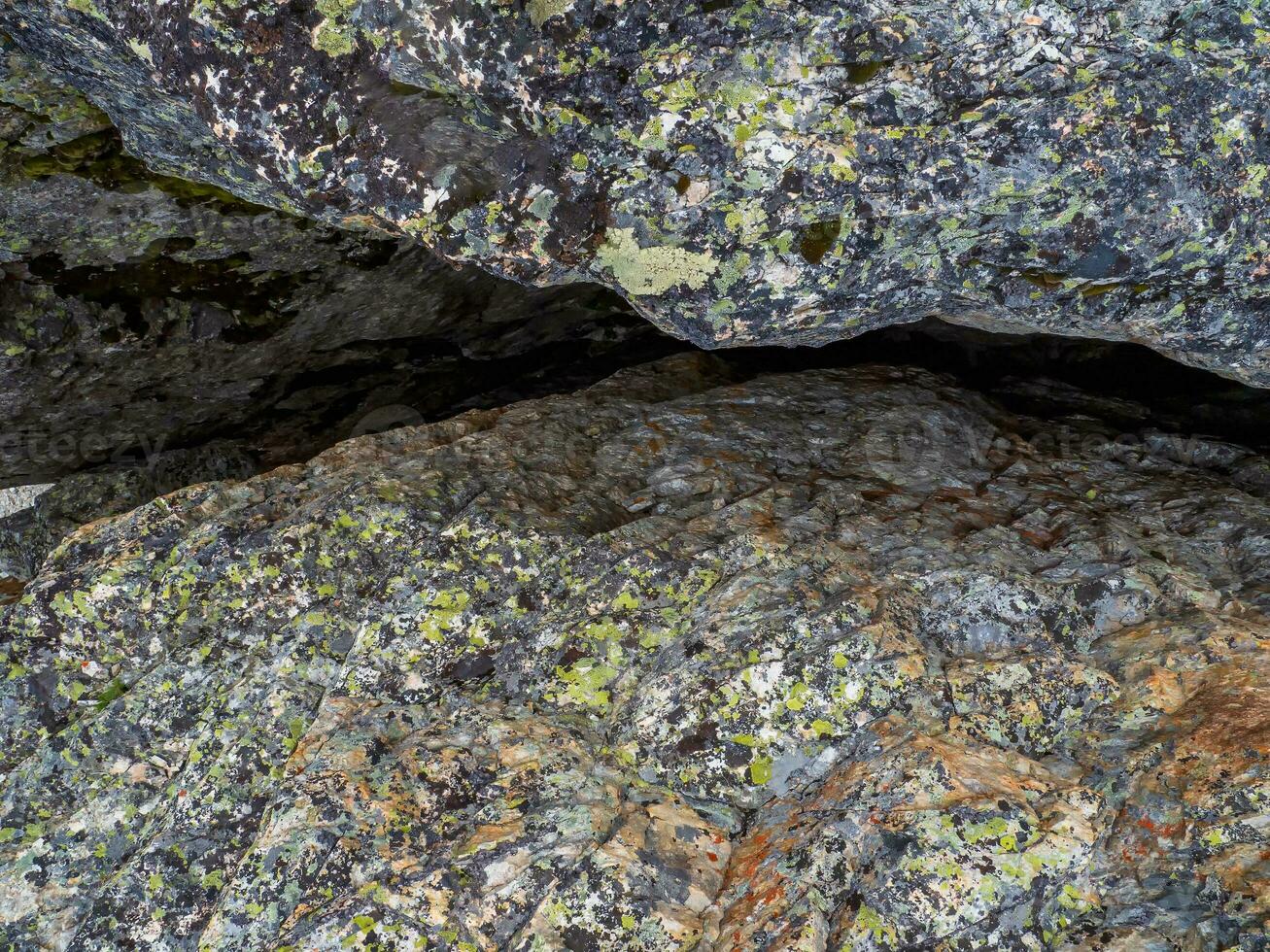 Crack in granite. Narrow entrance to the cave. Fault line or fracture in the rock, erosion, a crack in the stone. photo