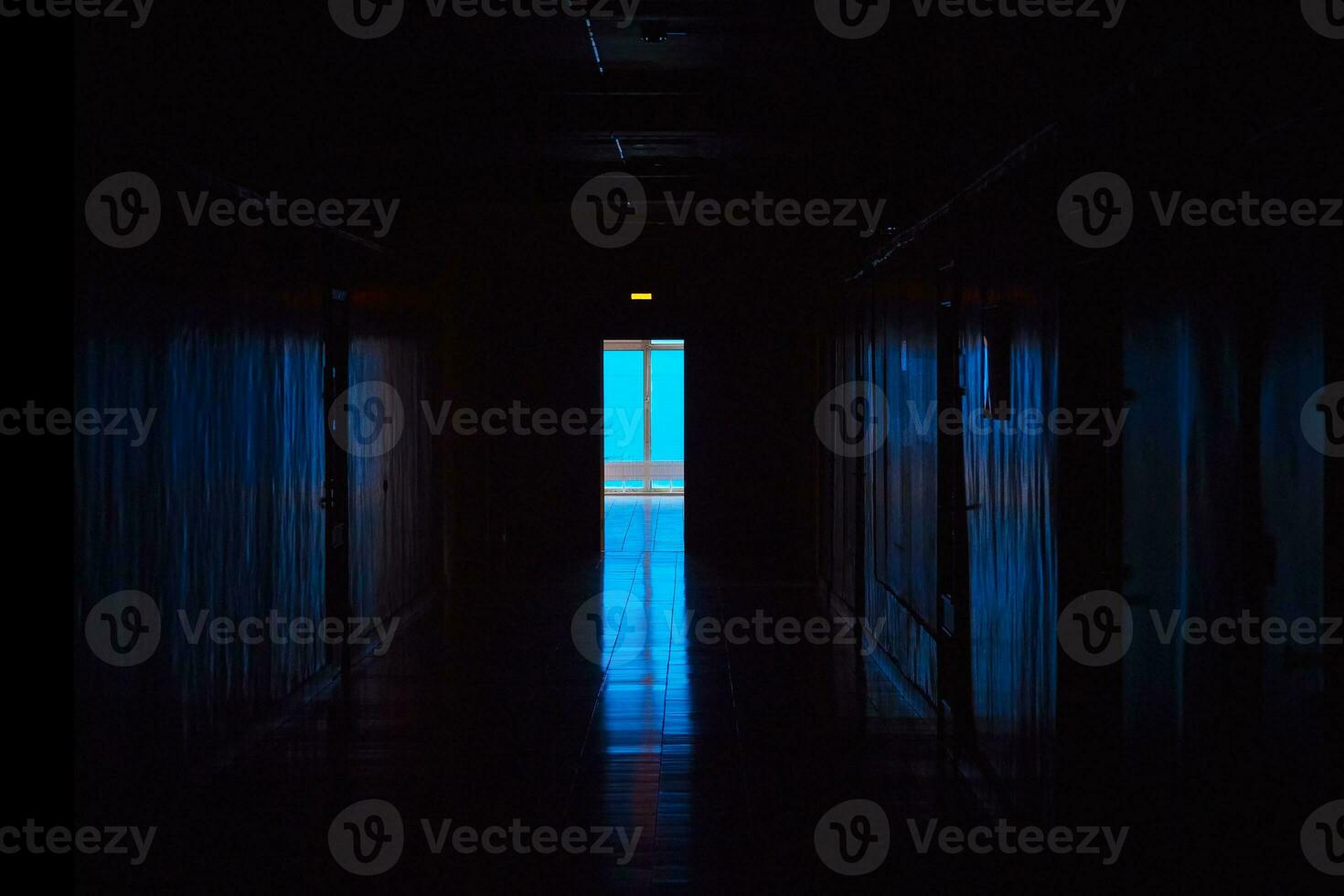 azul ligero a el final de un oscuro corredor. final de oscuro túnel con magia azul ligero. vacío oscuro corredor en hospital laboratorio. foto