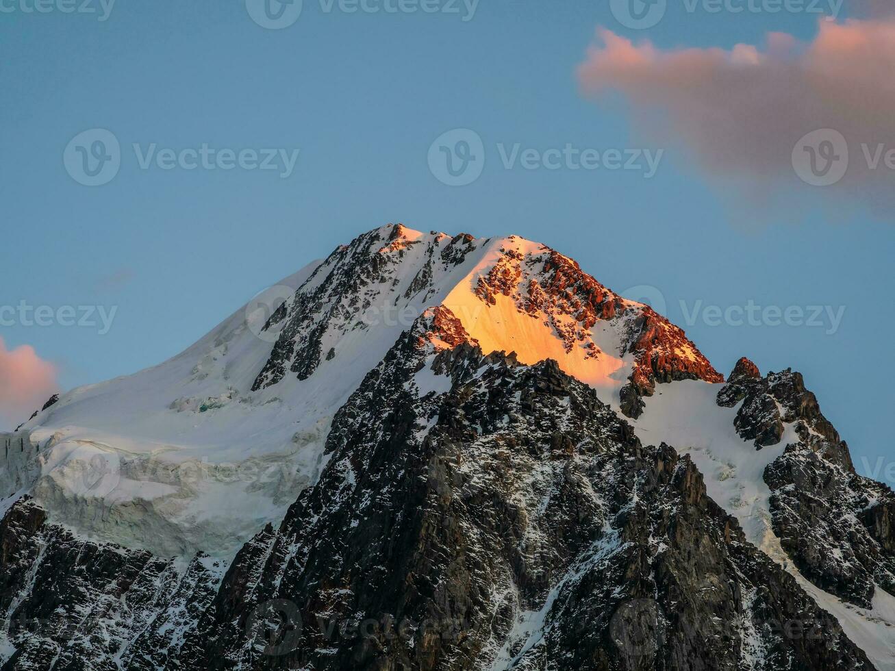 parte superior negro rocas en noche dorado Brillo Solar y nieve blanca puntiagudo cima. minimalista atmosférico paisaje con alto Nevado montaña con puntiagudo parte superior debajo cirro nubes en cielo. foto