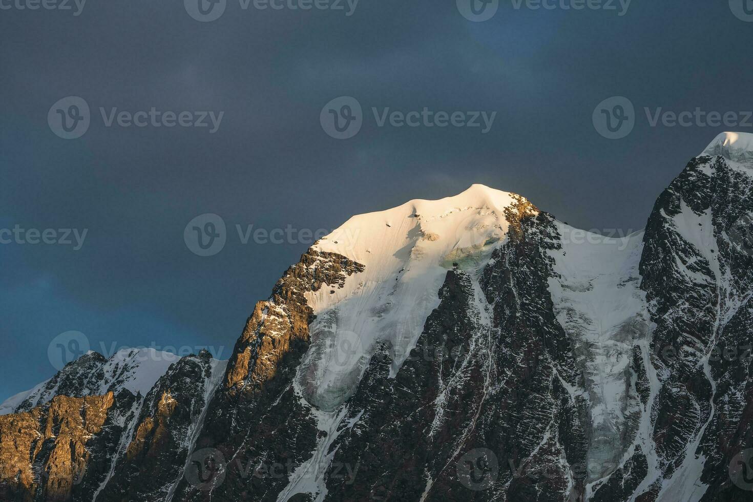 increíble paisaje con iluminado por el sol nieve montañas en nublado cielo a amanecer. oscuro escénico paisaje con grande glaciar en amanecer colores. foto