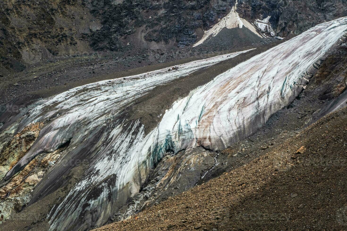 Nature background of dark glacier surface with cracks and scratches. Minimal natural backdrop of icy wall and blocks of ice from glacier close up. Beautiful nature texture of glacial wall. photo