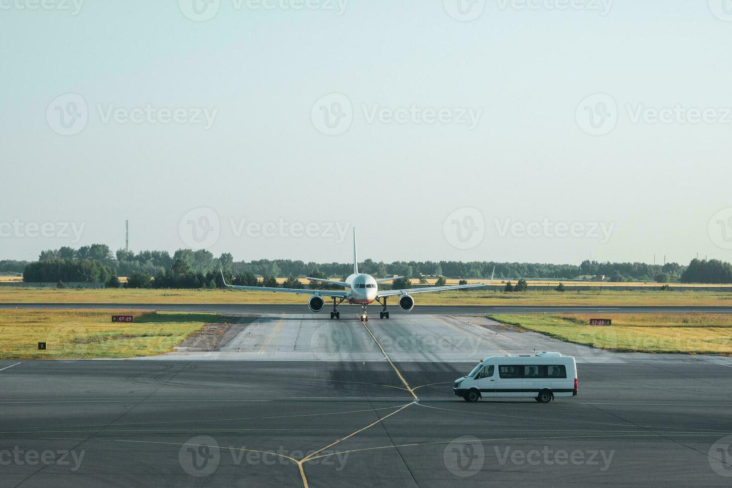 Transfer from the airport. White minibus is waiting for guests in front of the plane. High service, reception of guests. photo