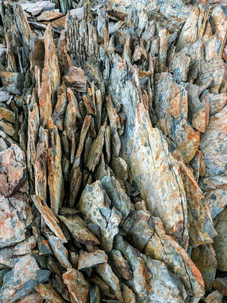 Sharp stones background. Abstract texture of split stone in dark gray color. Big cracked pointed stones closeup. photo