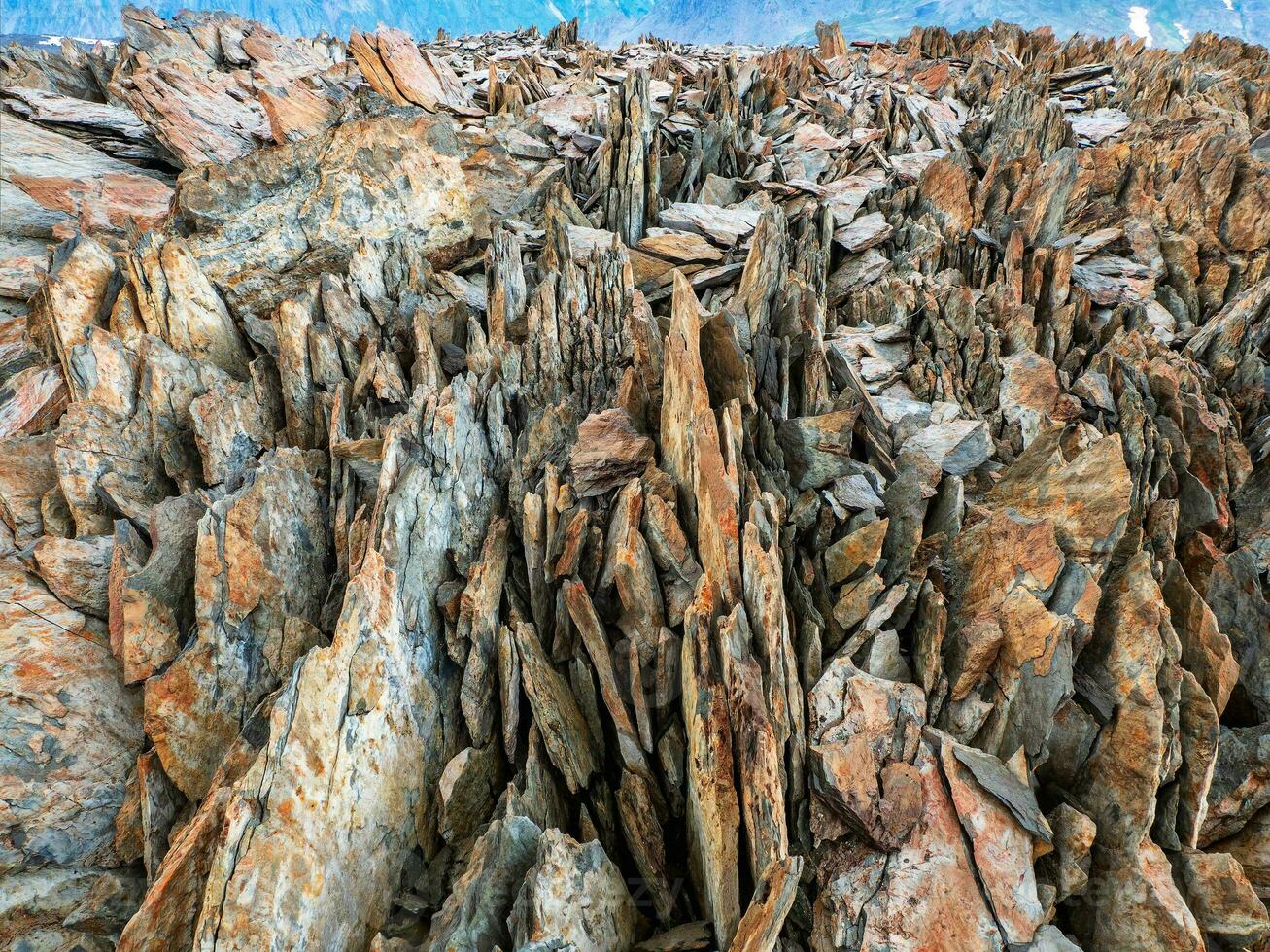 Texture of mountains. Dangerous sharp rocks. Sharp stones background. Abstract texture of split stone in dark gray color. Big cracked pointed stones closeup. photo