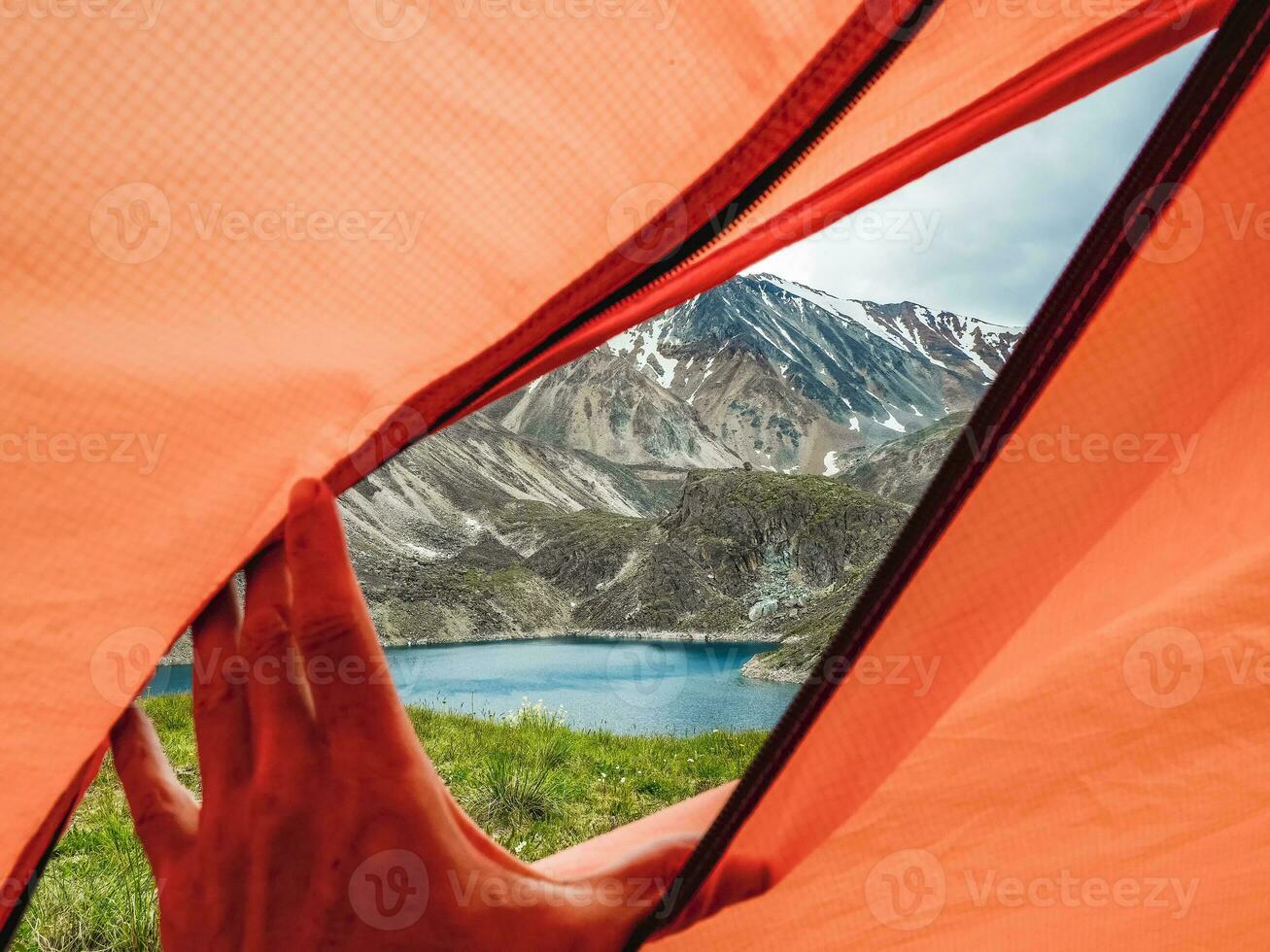View from inside the tent to high mountains. Hiking and tourism concept. photo