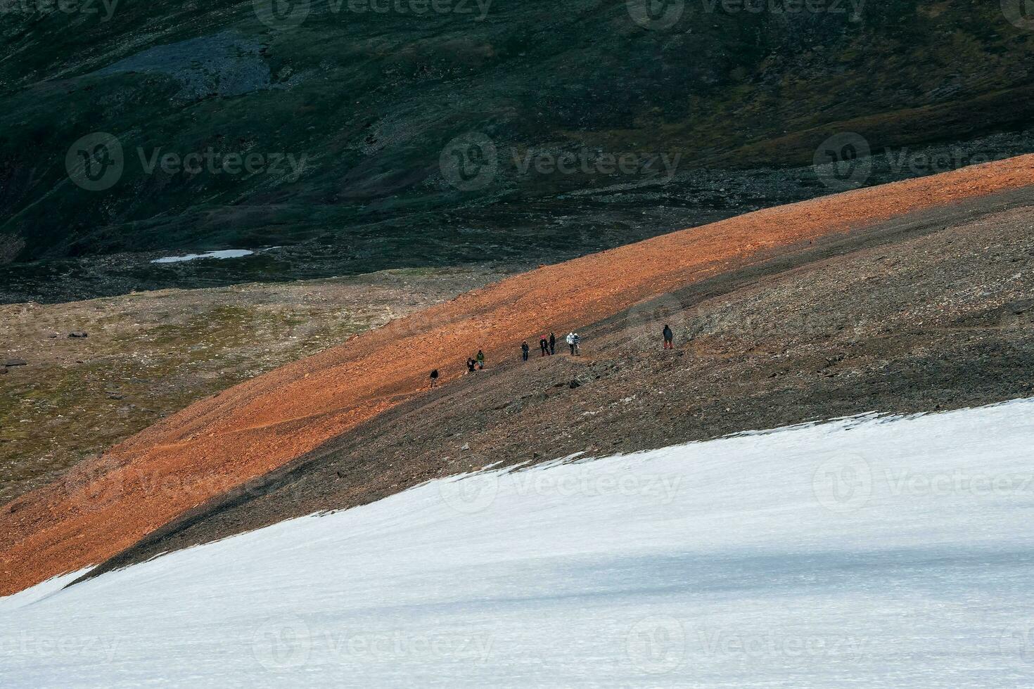 Difficult climb to the top of the mountain. Tourists come to top of snowy hill. Teamwork and victory, teamwork of people in difficult conditions. photo