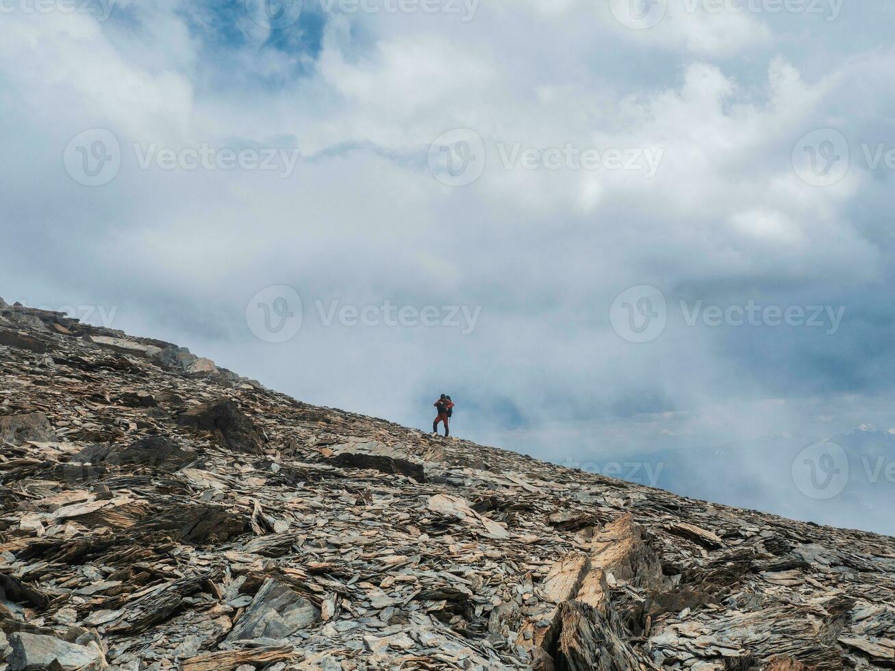 Heavy climbing on sharp rocks. Solo trekking in the mountains. Travel photographer lifestyle, hiking hard track, adventure concept in spring vacation. photo