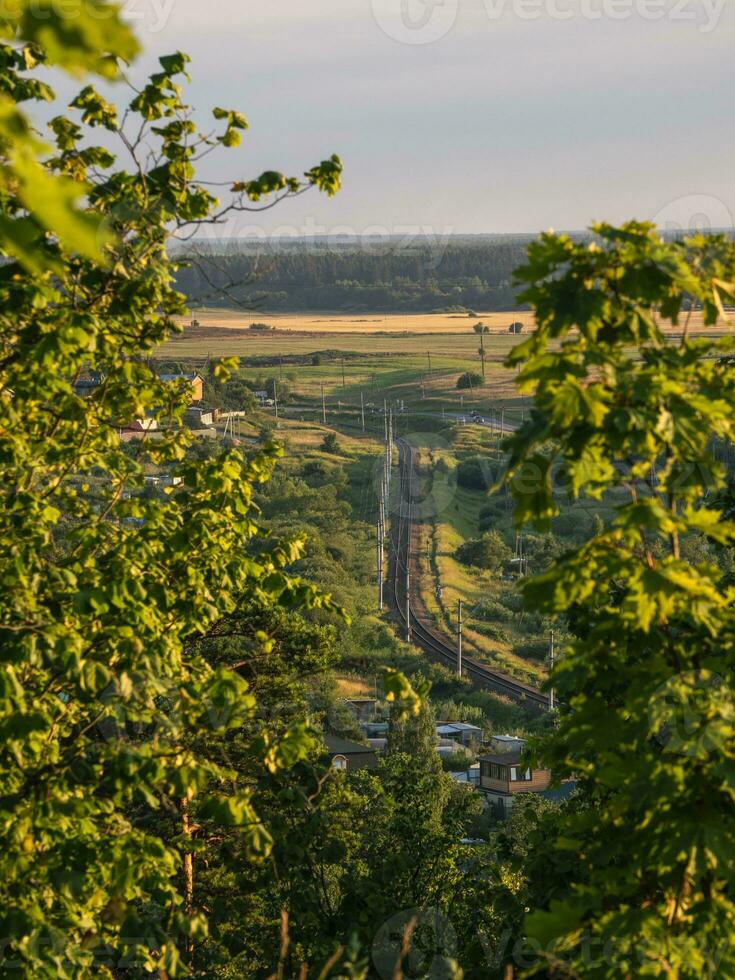 The railway bends in the distance. The railway has a soft focus of field and forest photo