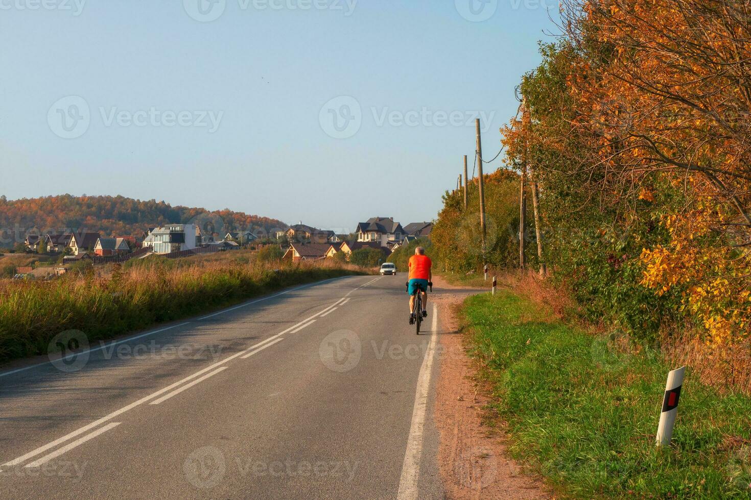 Travel by bike. A male cyclist on a country autumn road. photo