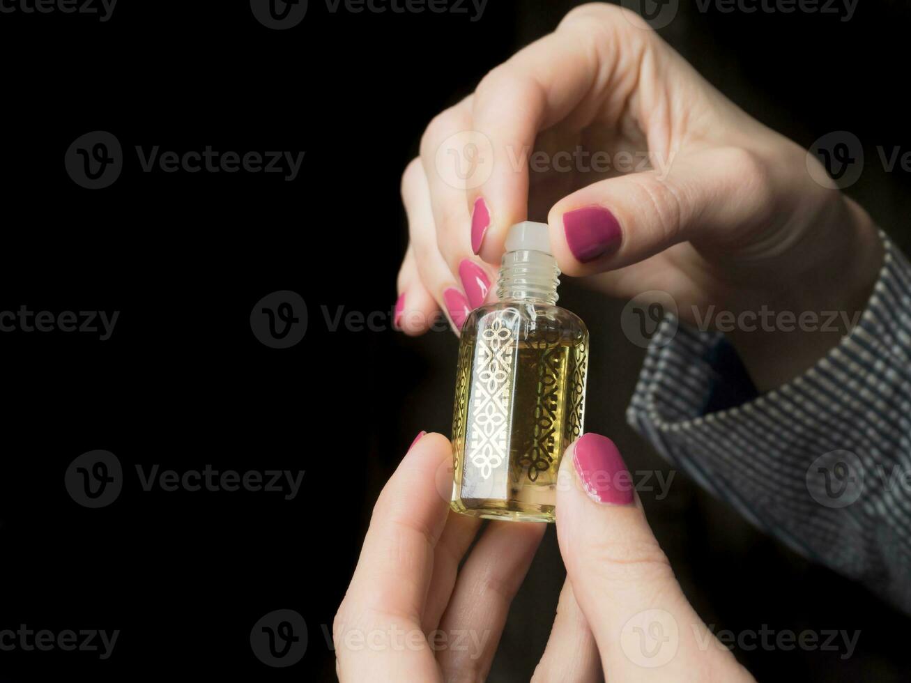 European hands of a woman with Arabian perfume oil. photo