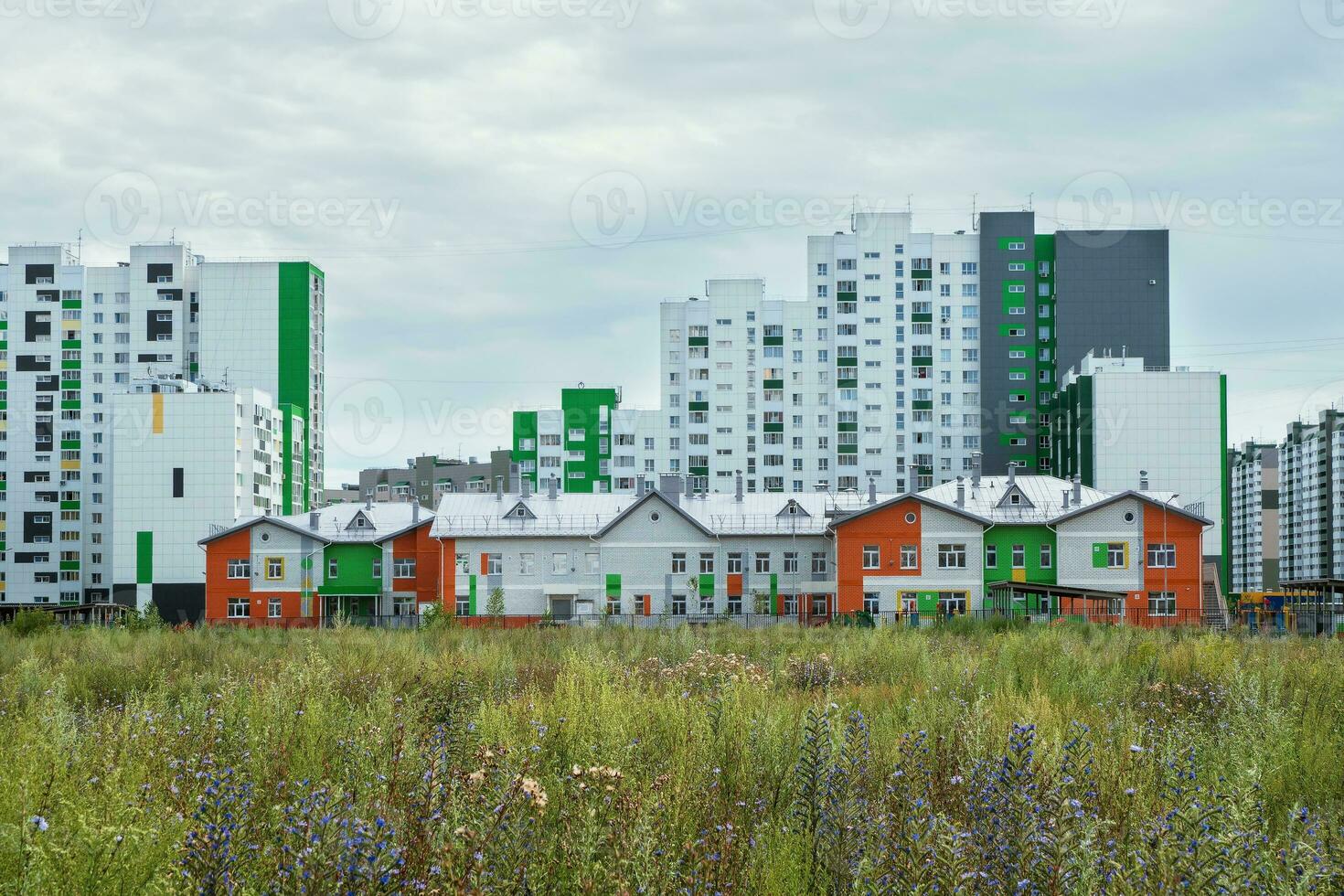 Modern construction, new neighborhood. Modern beautiful new buildings. Colored wall on the background of blue sky. photo