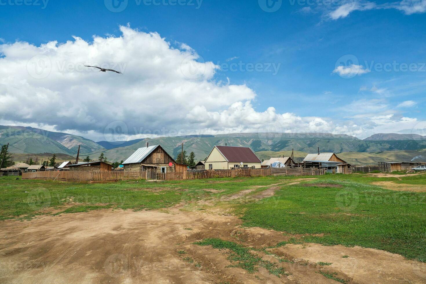 ruso siberiano pueblo con suciedad la carretera y tradicional antiguo de madera casas de madera casas en un antiguo siberiano Kurai aldea. foto