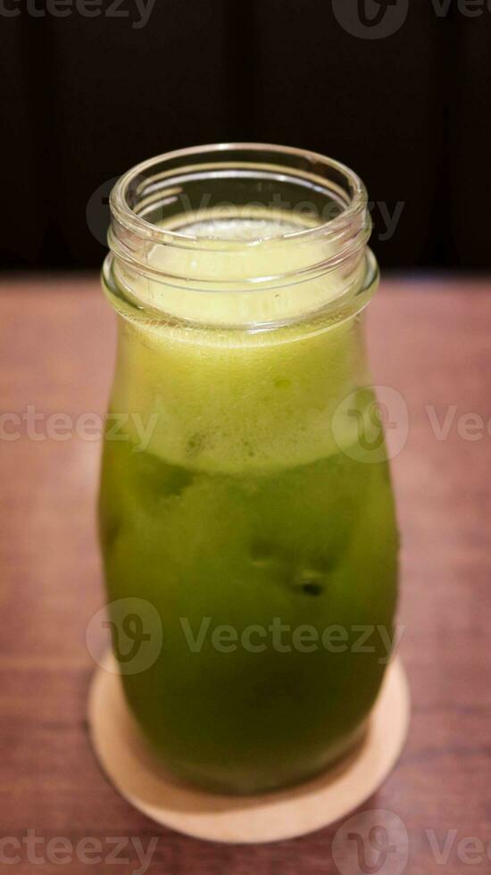 Healthy green vegetable juice in a glass bottle. photo