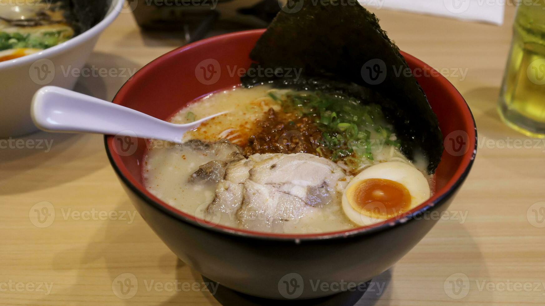 Modern style ramen with tonkotsu broth served with thin noodle, pork belly, and spring onions, special spicy miso with ground pork and fragrant garlic oil add kick to tenses. photo