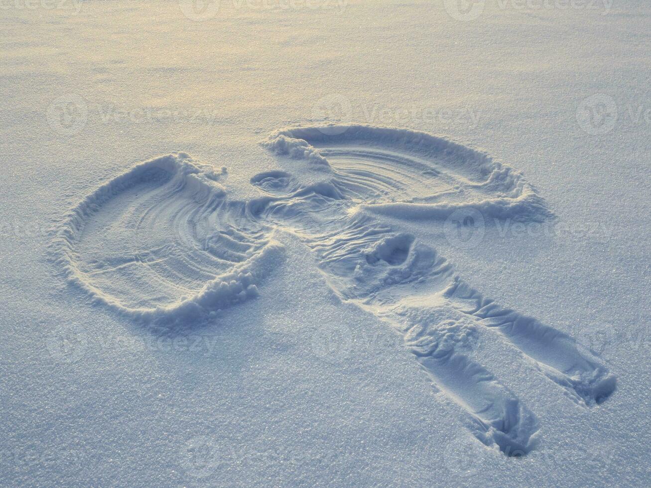 Snow angel made in the white snow. Top flat overhead view photo