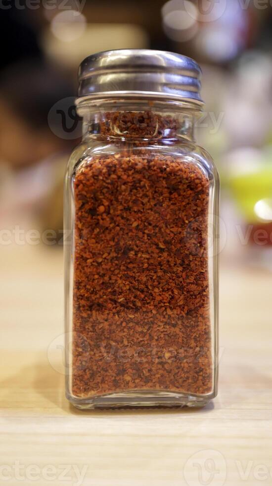 un pequeño vaso botella de seco rojo chile pimienta para condimento o Condimento. foto