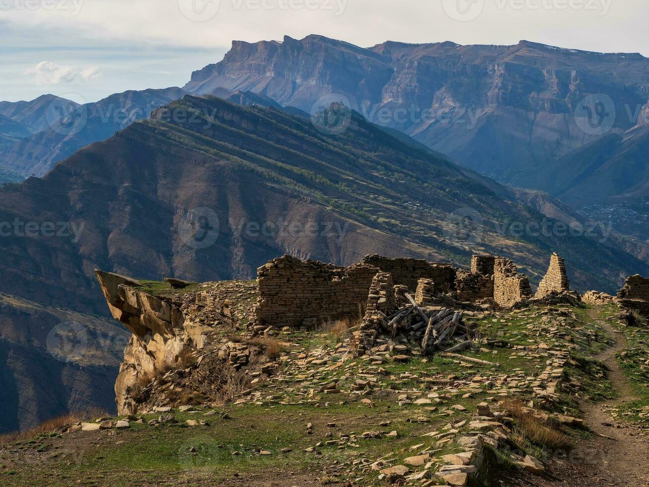 Ruins of an ancient mountain settlement. Ruins and towers of the aul ghost Goor in Dagestan in the evening light. Russia. photo