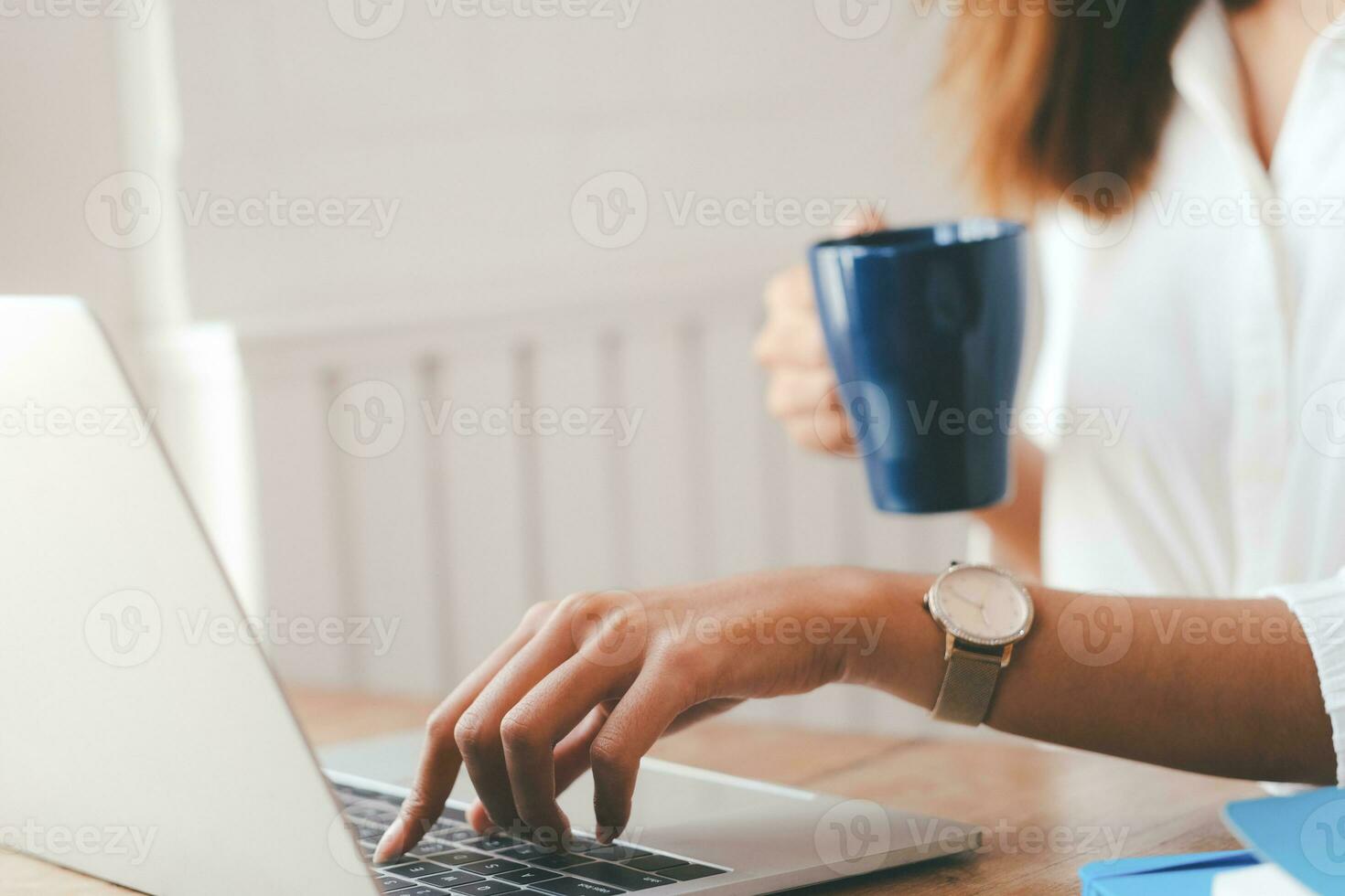 Beautiful woman using laptop at cafe while drinking coffee. photo
