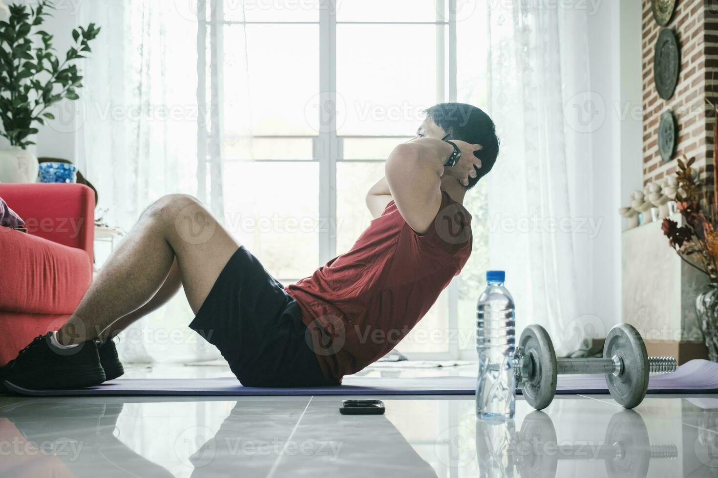 Male fitness instructor showing exercises training at home using laptop. photo