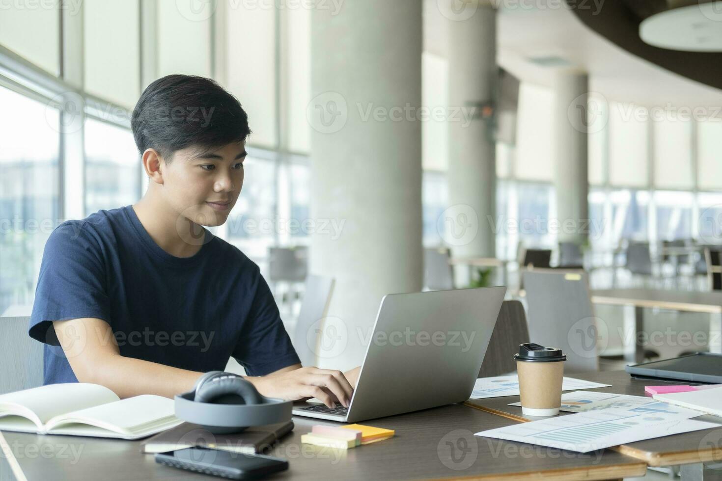 Young collage student using computer and mobile device studying online. photo
