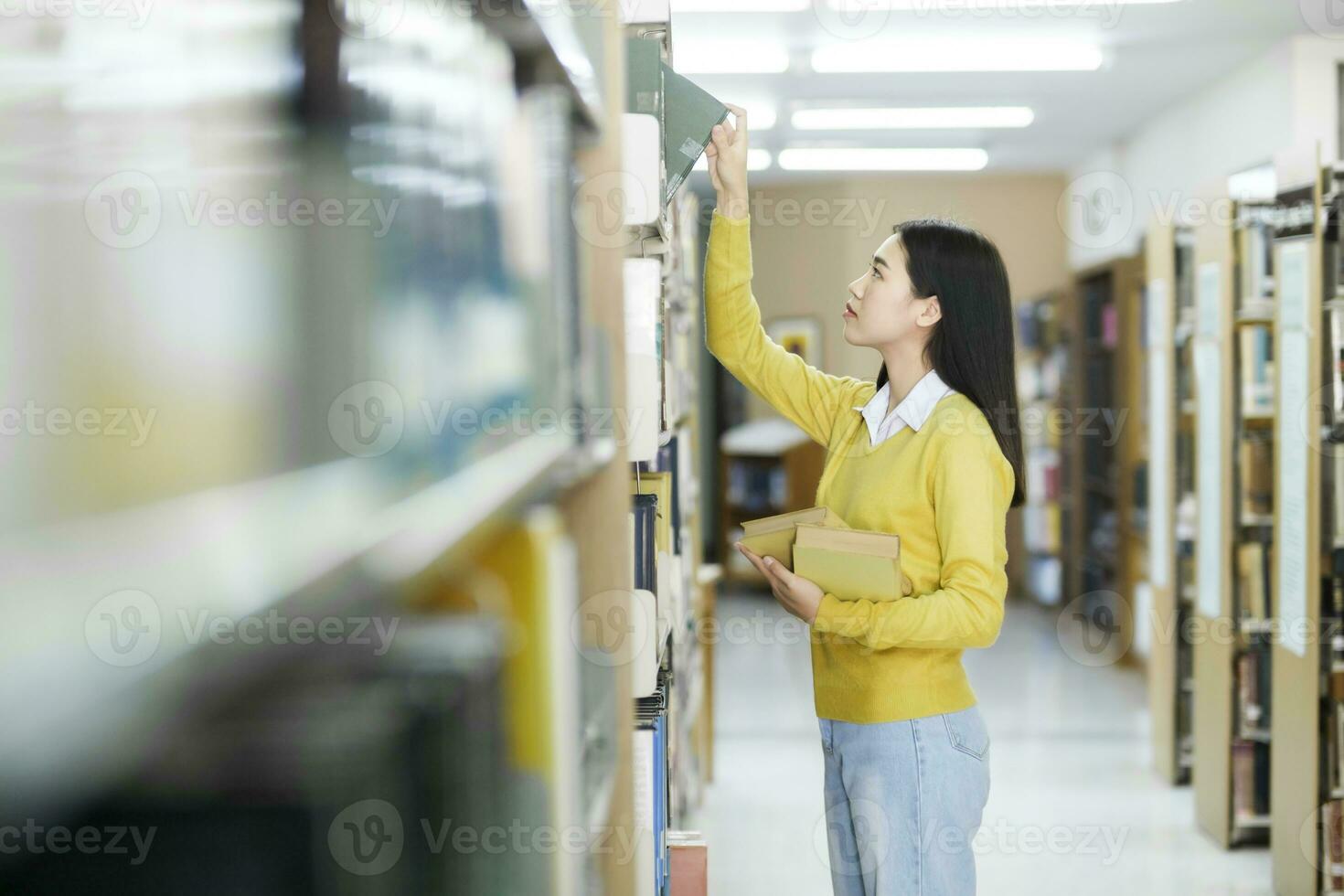 Student choosing and reading book at library. photo