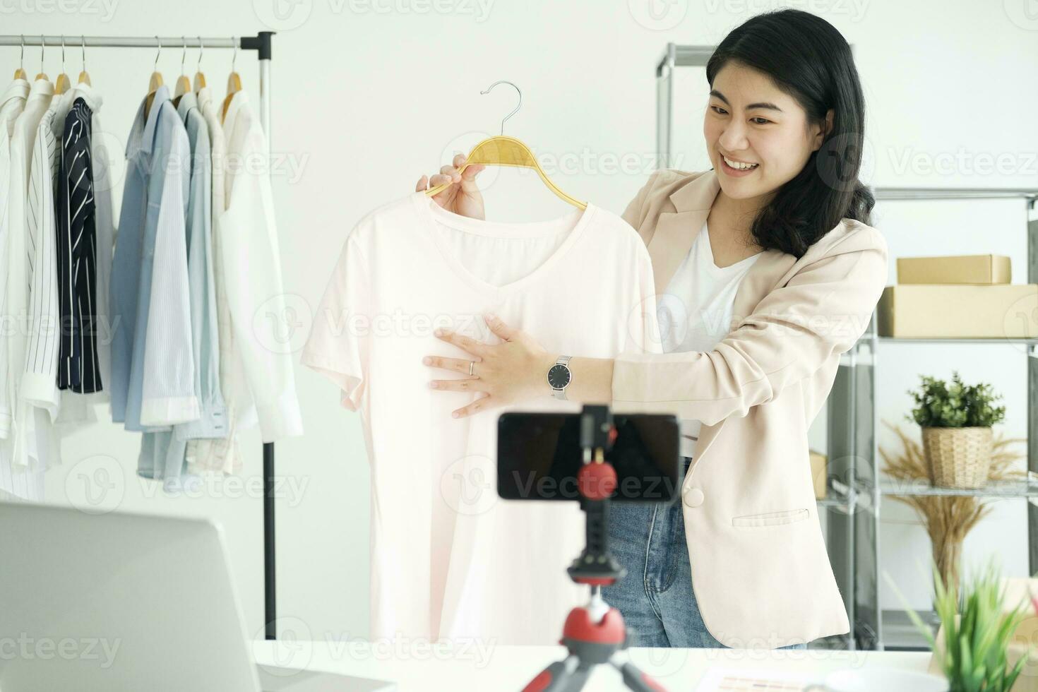 Businesswoman giving important pieces of advice while streaming video for women's clothing. photo