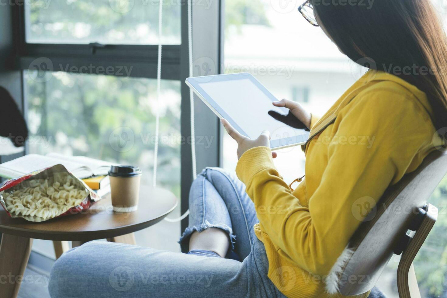 Young collage student using computer and mobile device studying online. photo