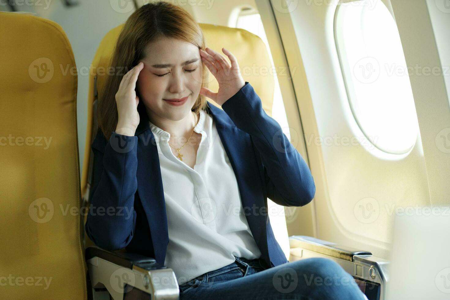 Businesswoman suffered headache sitting on airplane. photo