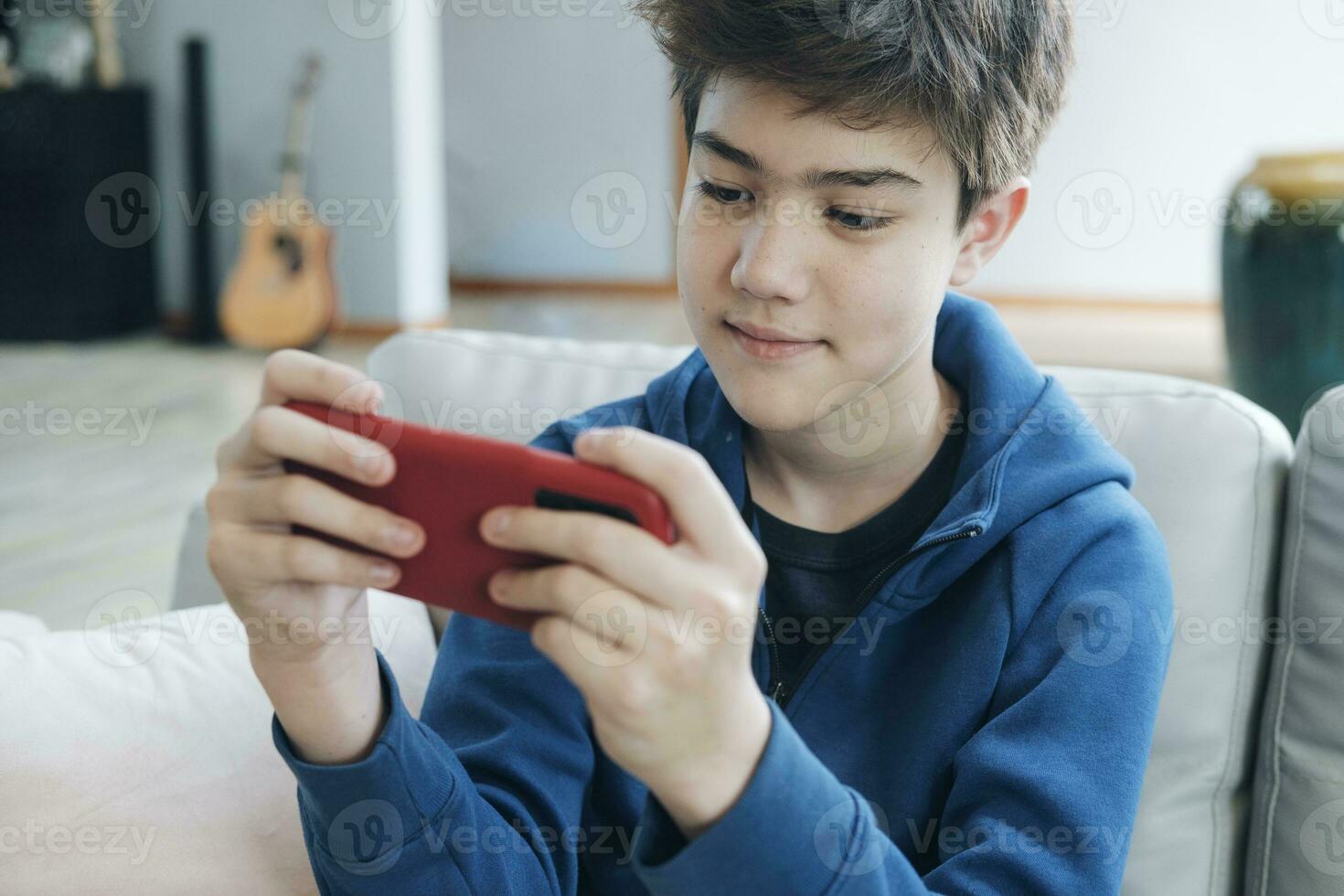 The boy who is playing online games in his mobile phone photo