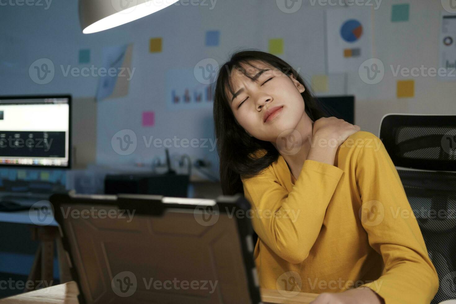 Young woman overtime work and feel shoulder and neck pain photo