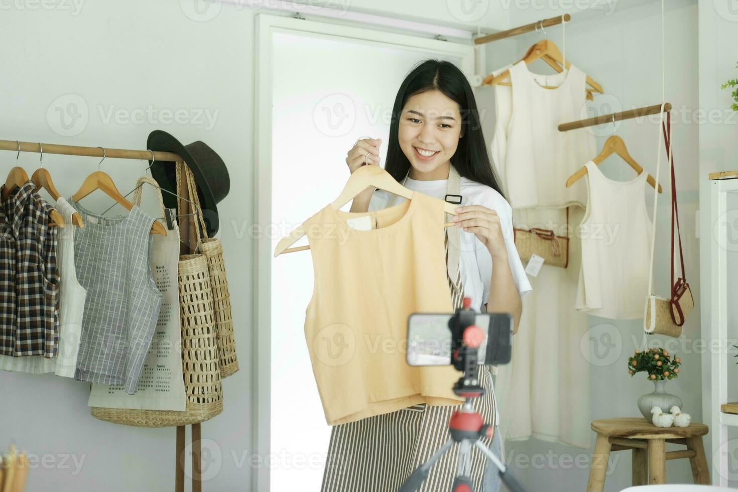 joven asiático mujer de negocios Moda blogger demostración paño con sonriente rostro. foto