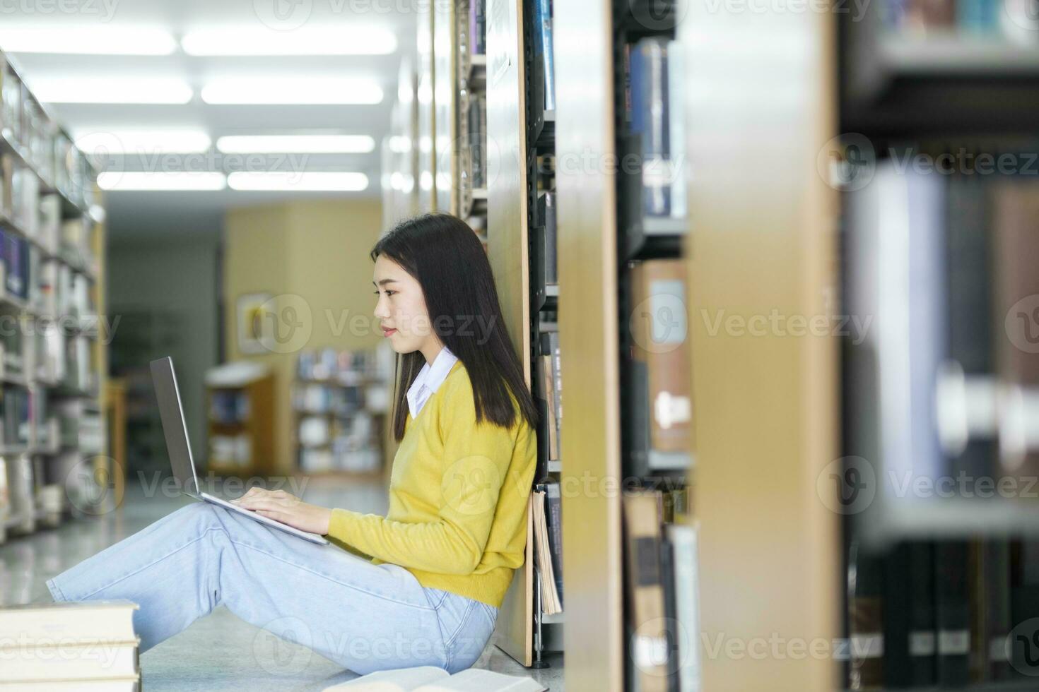 Student sitting on the floor and studying at library. photo
