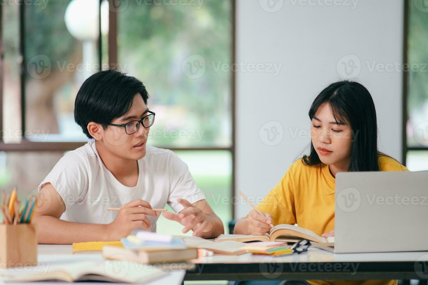 un asiático estudiantes son leyendo libros y estudiar, tutoría juntos. foto