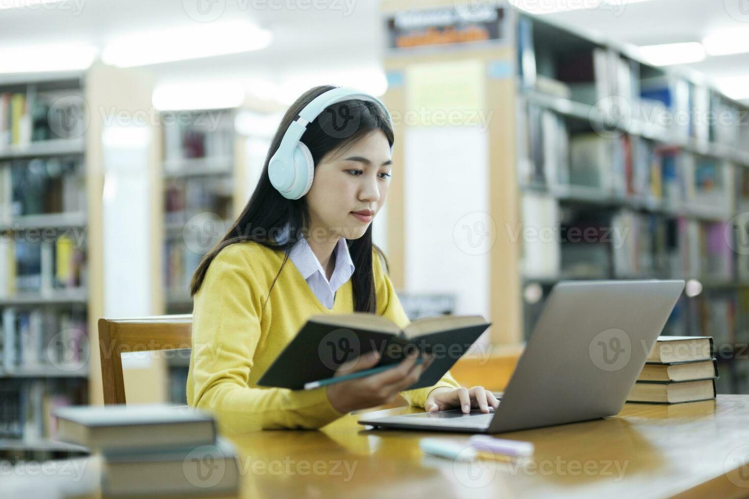 Student sitting and studying with laptop at library. photo