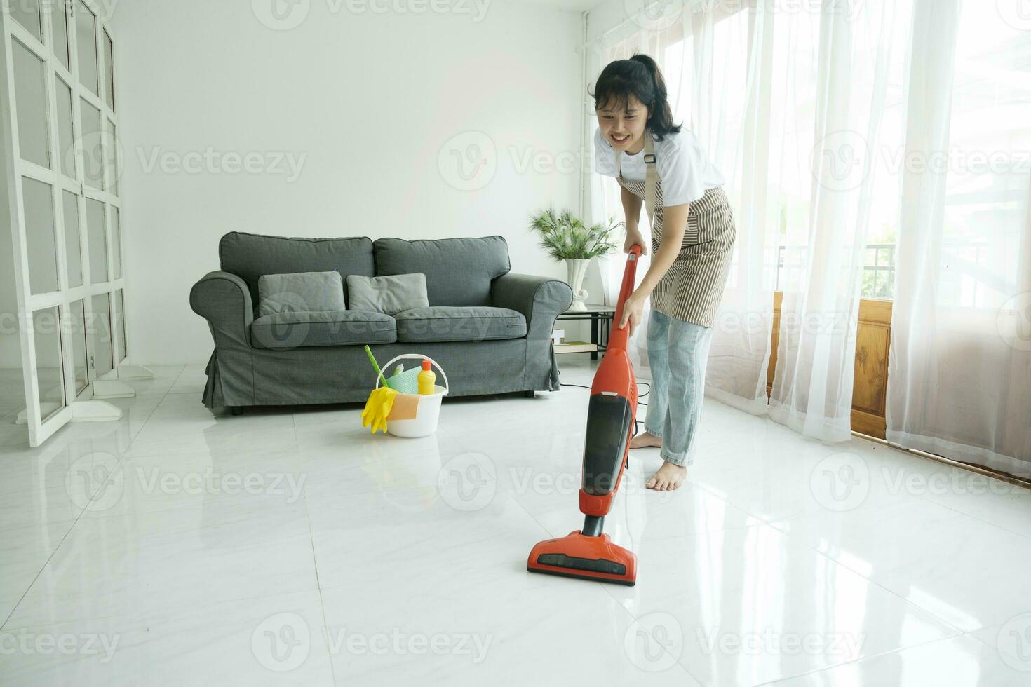 joven mujer limpieza casa con vacío limpiador. foto