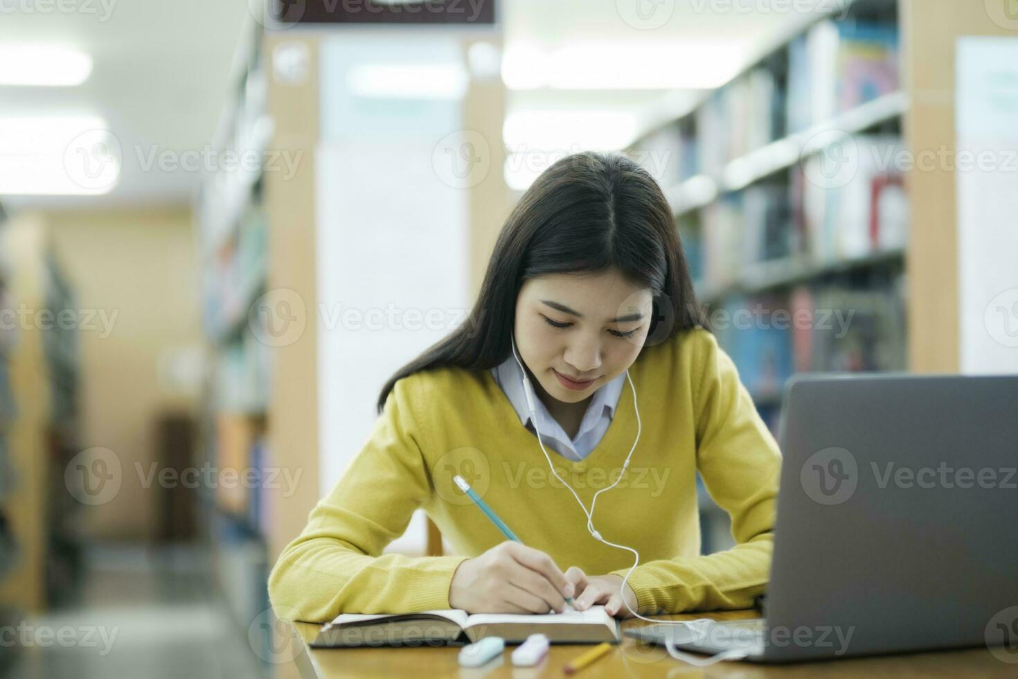 Student studying at library with laptop. photo