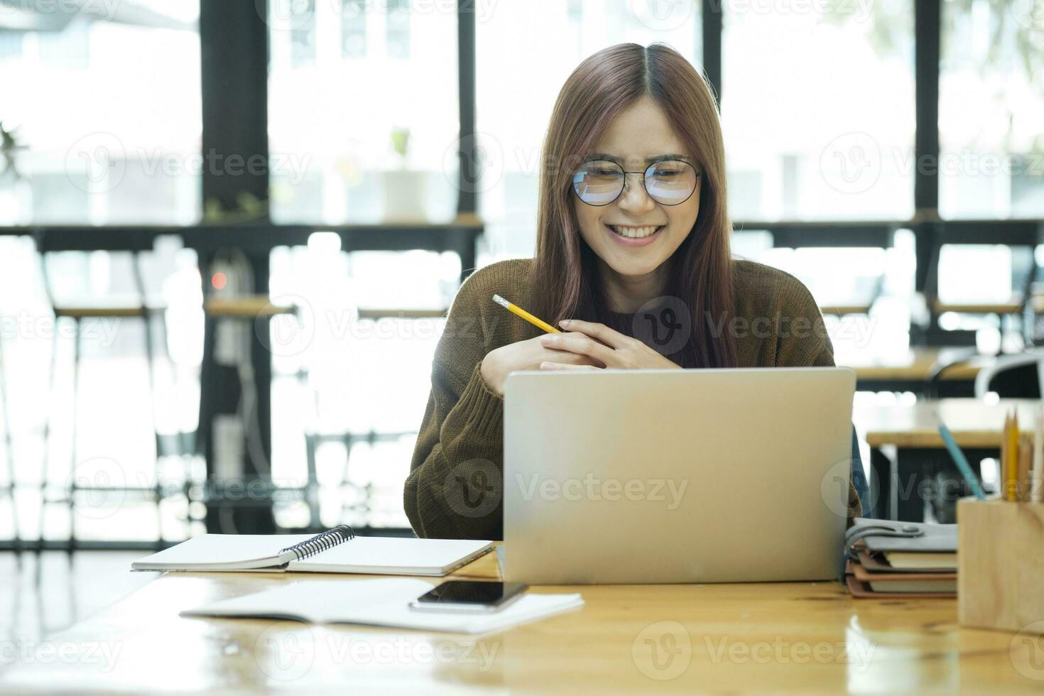 Young collage student using computer and mobile device studying online. photo