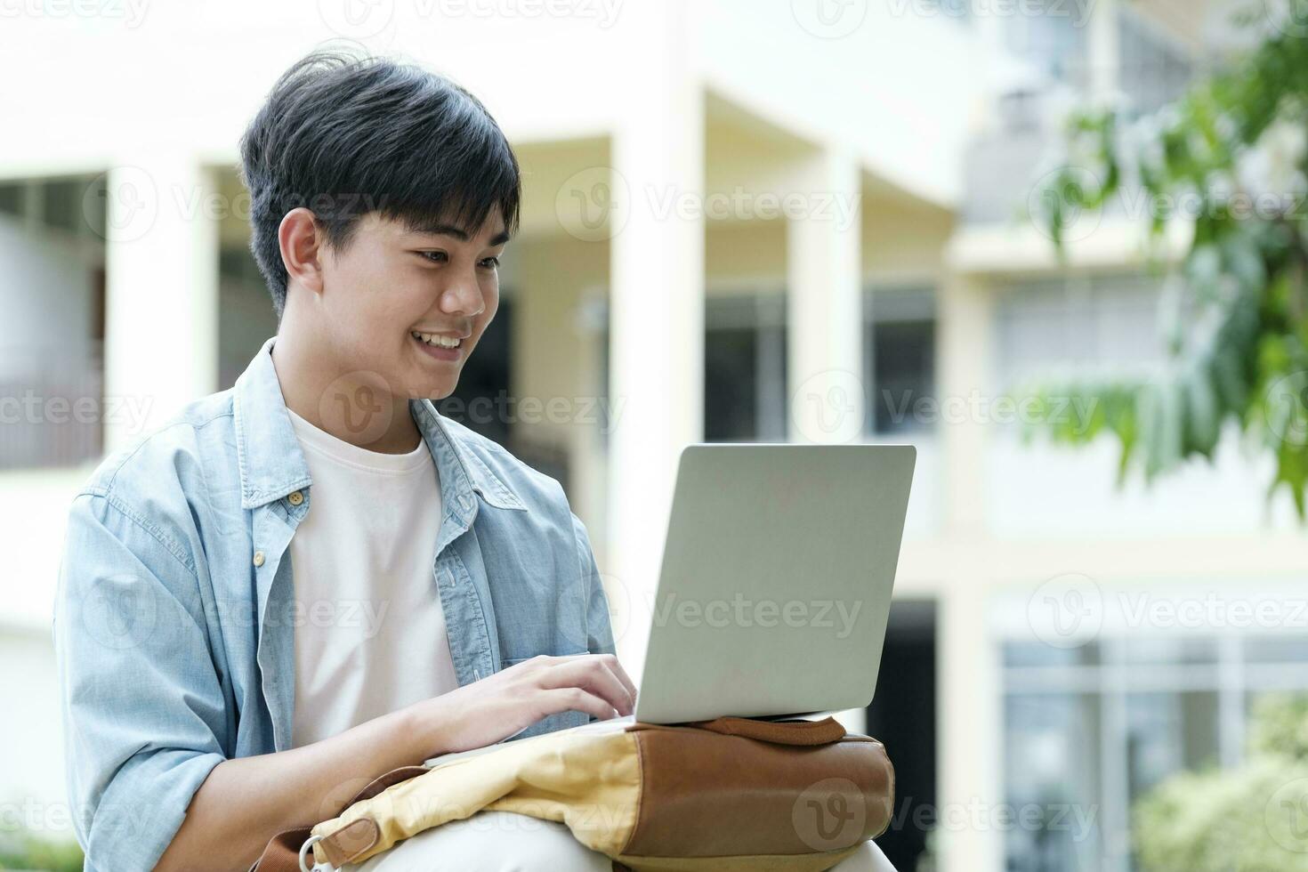 Young collage student using computer and mobile device studying online. photo